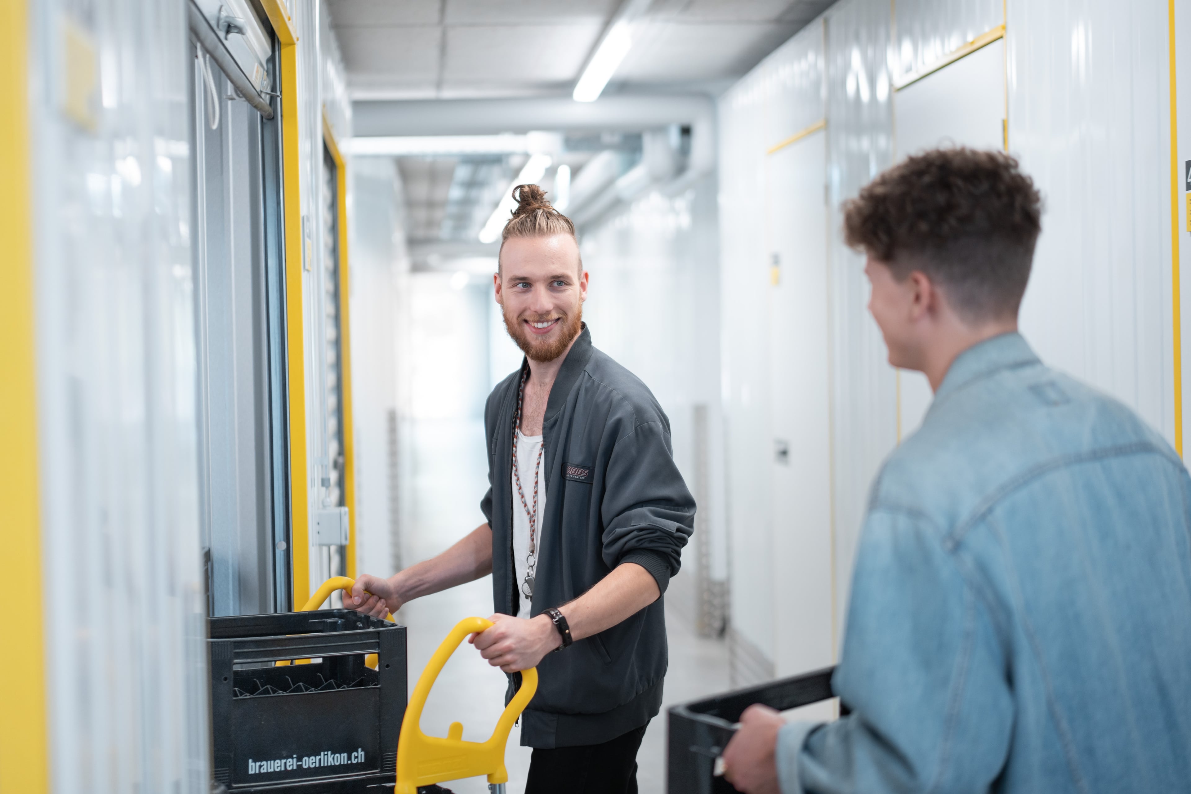 Deux hommes amènent des bidons et des cagettes dans leur entrepôt chez Zebrabox.