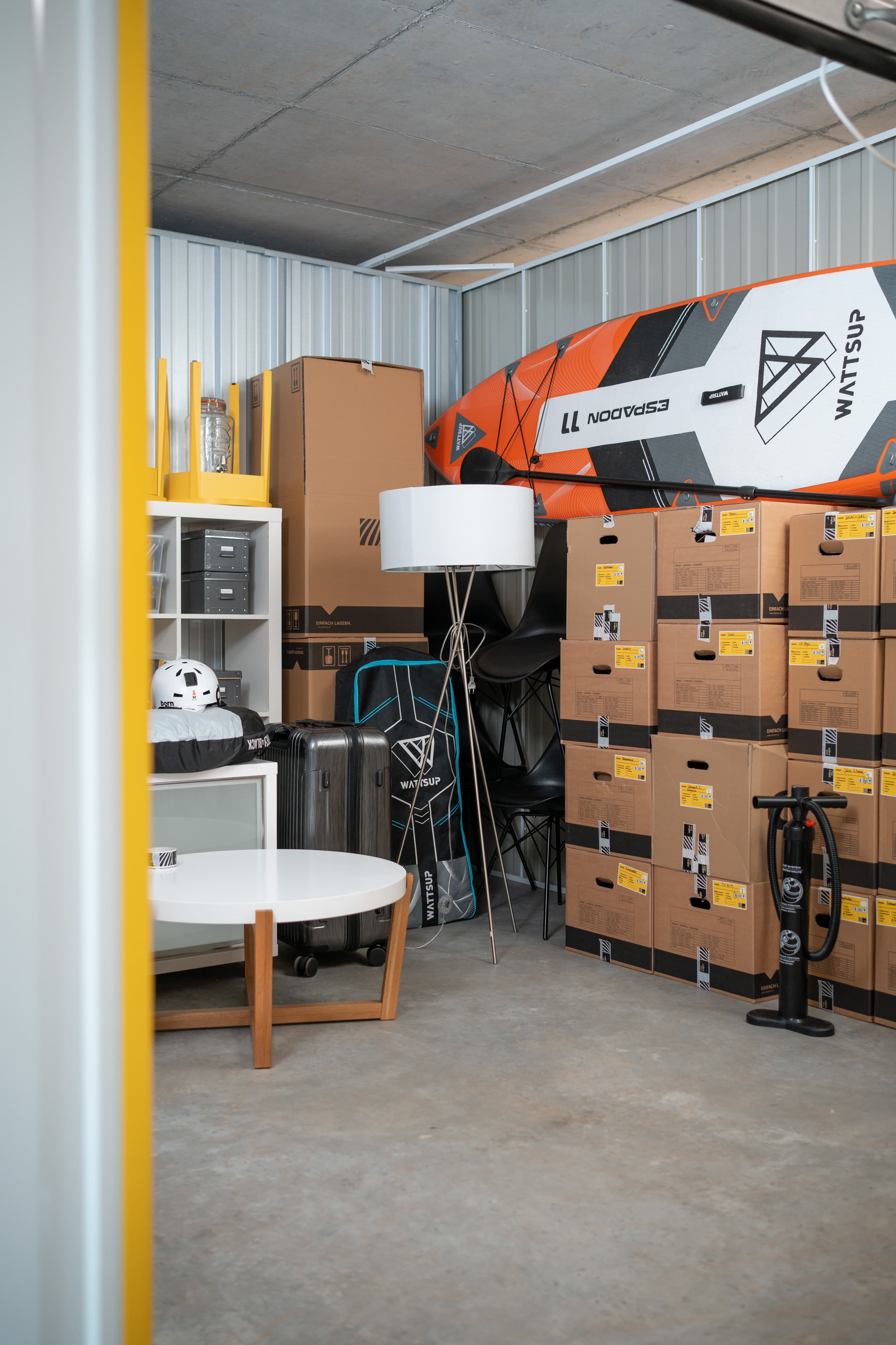 Un espace de stockage chez Zebrabox rempli de mobilier, d'équipements sportifs et de caisses de déménagement.