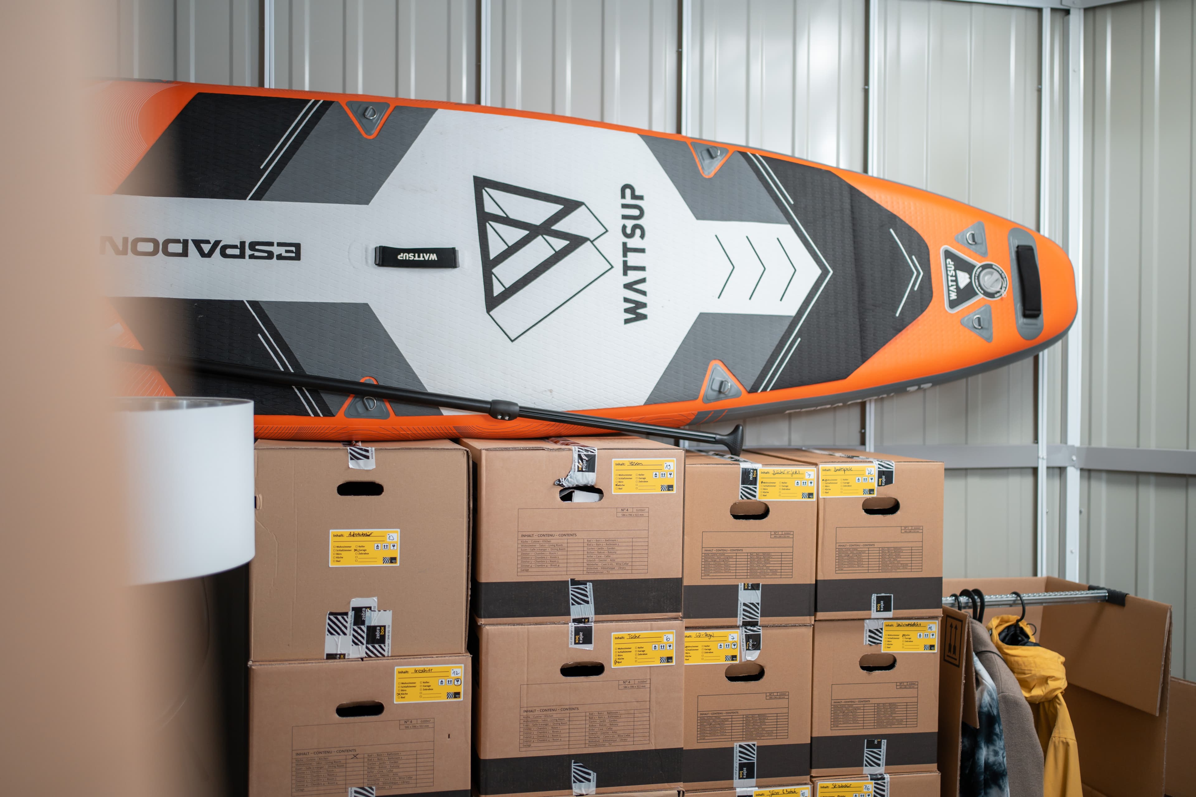 Un espace de stockage chez Zebrabox rempli de mobilier, d'équipements sportifs et de caisses de déménagement.